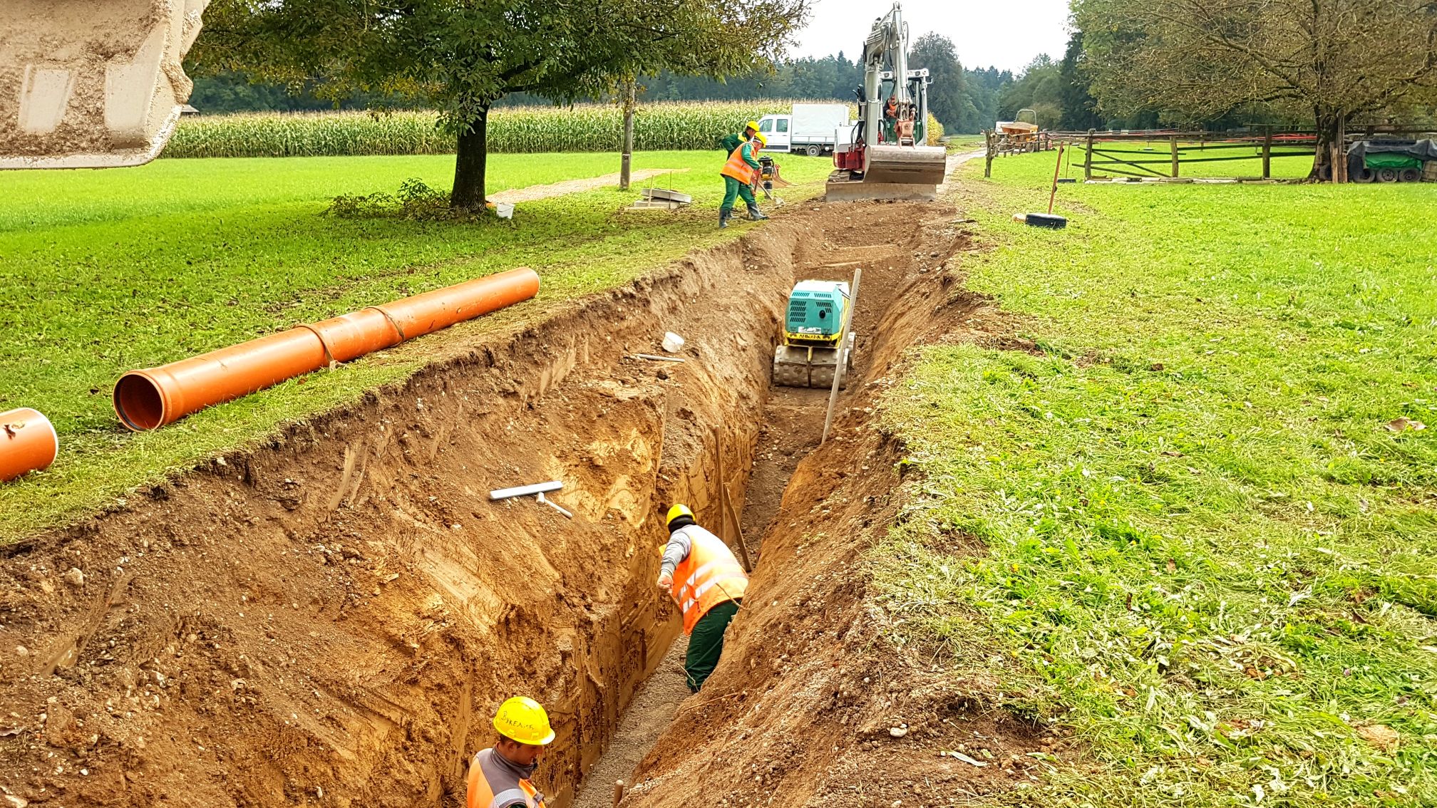 Construction workers installing a pipeline in a field