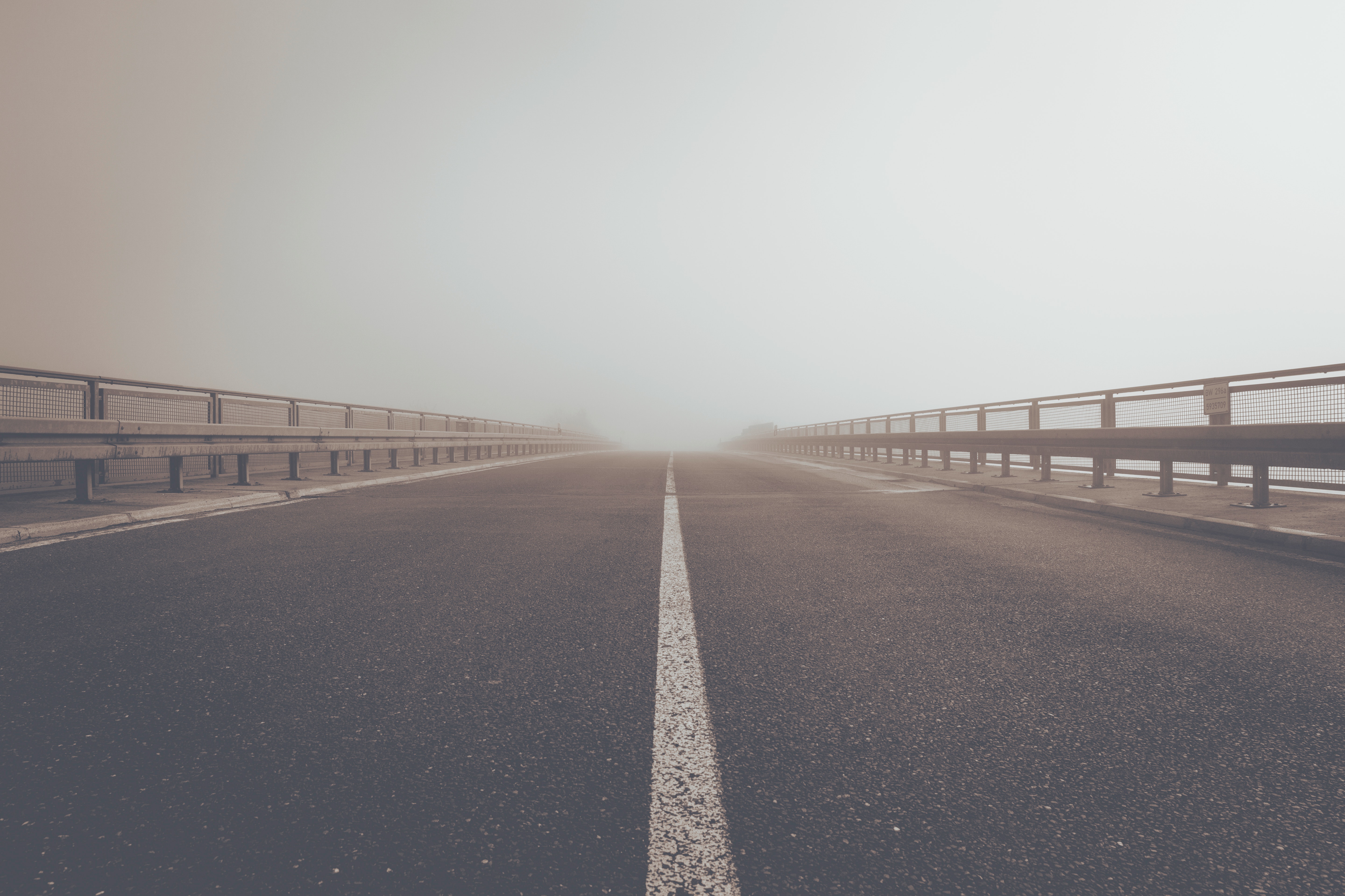 Road with guardrails in foggy atmosphere